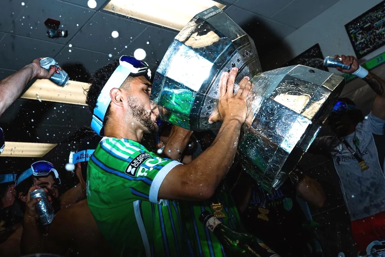 Christian Roldon drinks beer out of the Leagues Cup trophy after wining the tournament in 2025