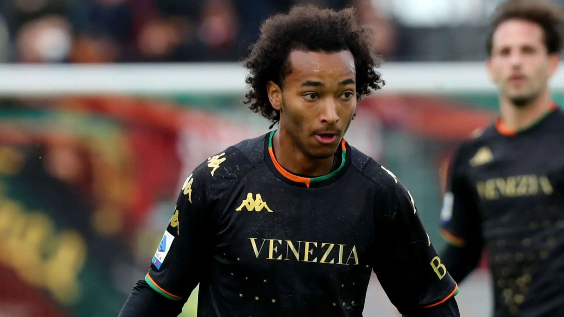 Gianluca Busio in Venezia FC jersey during a match, with teammates in background.